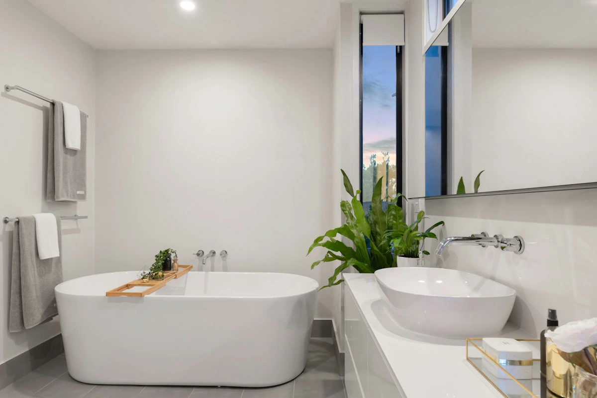 Baño moderno recién reformado con azulejos claros y grifería nueva